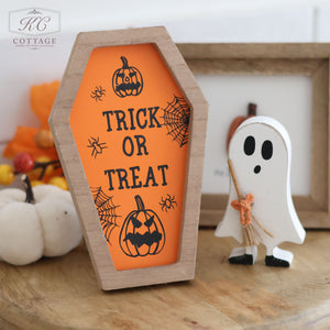 The Halloween Coffin Shaped Signs are crafted from high-quality wood and feature an orange, coffin-shaped design with the text "TRICK OR TREAT" and black Halloween motifs such as spider webs and jack-o'-lanterns. Accompanying the sign is a white ghost figure holding a broom, creating the perfect spooky Halloween decor.